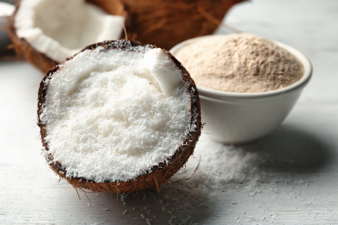 Desiccated Coconut in Nut on Wooden Table